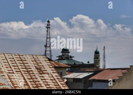 Tomba di una moschea (Masjid) insieme alle torri del cellulare sono viste nella città di Sopore del distretto Baramulla, Jammu e Kashmir, India il 21 agosto 2020. La connessione Internet ad alta velocità 4G è stata ripristinata domenica tarda nel distretto centrale di Ganderbal nel Kashmir e a Udhampur a Jammu su base trial fino al settembre 8, ponendo fine a un periodo di blackout di un anno dall'annullamento dell'articolo 370. (Foto di Nasir Kachroo/NurPhoto) Foto Stock