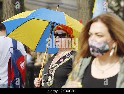 Una donna con un ombrello nei colori della bandiera Ucraina partecipa a una parata militare non ufficiale chiamata "marcia dei difensori dell'Ucraina" per celebrare la Giornata dell'Indipendenza a Kyiv, Ucraina, il 24 agosto 2020. Alla marcia hanno preso parte uomini di servizio ucraini, volontari e parenti di soldati ucraini morti. L'Ucraina celebra il 29th° anniversario dell'indipendenza il 24 agosto 2020. (Foto di Str/NurPhoto) Foto Stock