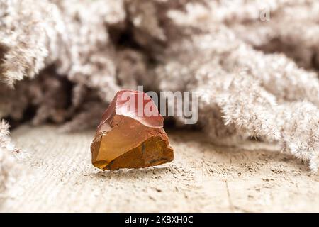 Bell'esempio di pietra di selce rossa e arancione su sfondo di legno Foto Stock