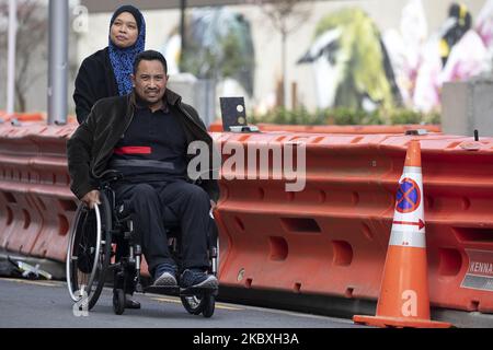 Nor AzilaÂ (L) spinge suo marito e sopravvissuto alla moschea gemella shootingsÂ Rahimi Ahmad sulla sedia a rotelle come leaveÂ Christchurch High CourtÂ durante il secondo giorno dell'udienza di quattro giorni di condanna di Brenton Harrison Tarrant a Christchurch, Nuova Zelanda, il 25 agosto 2020. Il supremacista bianco australiano Tarrant, 29 anni, che ha compiuto l'attacco a due moschee il 15 marzo 2019, sarà condannato a 51 omicidi, 40 tentativi di omicidio e una accusa ai sensi della legge sulla repressione del terrorismo. (Foto di Sanka Vidanagama/NurPhoto) Foto Stock