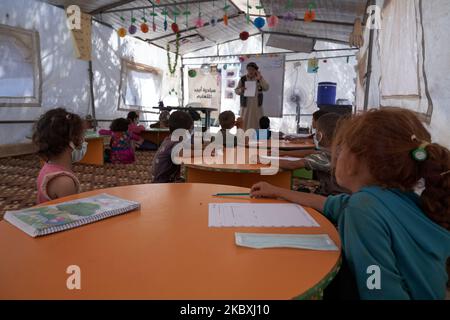 Gli studenti siriani seguono una lezione di matematica in un campo profughi vicino ai confini siriano-turchi a Idlib, Siria, il 25 agosto 2020. (Foto di Karam Almasri/NurPhoto) Foto Stock