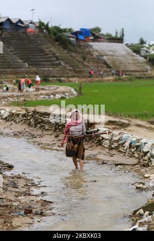 Una donna Rohingya raccoglie boschi di fuoco in una linea fognaria nel campo profughi di Chakmarkul a Teknaf, il Bazar di Cox, Bangladesh, il 26 agosto 2020. (Foto di Rehman Asad/NurPhoto) Foto Stock