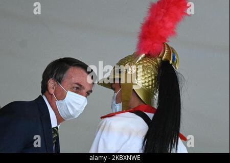 Jair Bolsonaro, Presidente del Brasile, è visto accanto ad una guardia presidenziale prima di partecipare alla cerimonia di celebrazione della Giornata Nazionale del Volontariato in mezzo alla pandemia del coronavirus (COVID-19) al Palazzo Planalto a Brasilia, Brasile, il 28 agosto 2020. (Foto di Andre Borges/NurPhoto) Foto Stock