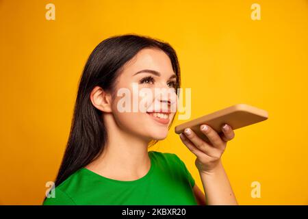 Comando vocale, motore di ricerca e app mobile. Allegro emotivo giovane donna caucasica in mano al telefono e fare una chiamata o canta in audio app, isolato su Foto Stock