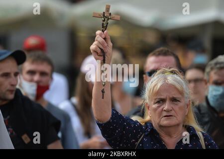 Una donna che ha una croce visto con i membri delle organizzazioni nazionaliste di estrema destra durante una contro protesta, contro LGBT e la marcia di uguaglianza. L'edizione di quest'anno della marcia per l'uguaglianza è stata modificata in un formato diverso a causa delle misure imposte dal governo e dalla zona "Stato giallo" per la città di Cracovia imposte dal Ministero della Salute solo un paio di giorni fa. La marcia annuale si è svolta intorno alla piazza principale. Sabato 29 agosto 2020, a Cracovia, Malopolskie Voivodato, Polonia. (Foto di Artur Widak/NurPhoto) Foto Stock