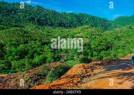 Paesaggio di montagne con foresta tropicale verde e strada al centro, alba nella giungla, con nuvole Foto Stock