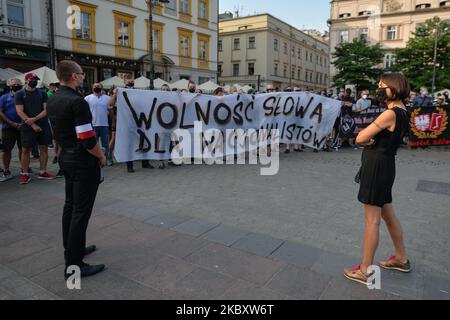 Un attivista pro-LGBT osserva i membri delle organizzazioni nazionaliste di estrema destra e gli attivisti pro-vita visti durante una contro protesta, contro LGBT e la marcia per l’uguaglianza. L'edizione di quest'anno della marcia per l'uguaglianza è stata modificata in un formato diverso a causa delle misure imposte dal governo e dalla zona "Stato giallo" per la città di Cracovia imposte dal Ministero della Salute solo un paio di giorni fa. La marcia annuale si è svolta intorno alla piazza principale. Il 29 agosto 2020, a Cracovia, piccola Polonia Voivodato, Polonia. (Foto di Artur Widak/NurPhoto) Foto Stock