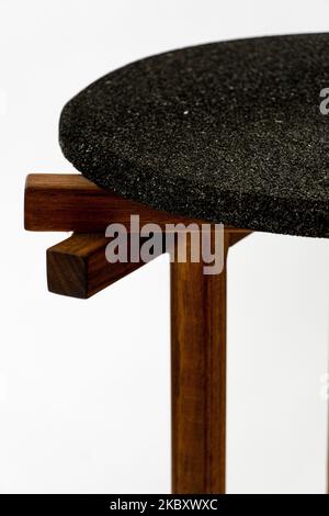 Particolare di un giunto in legno incollato di una gamba per sedie. Il materiale utilizzato per lo sgabello è il legno di ciliegio Foto Stock