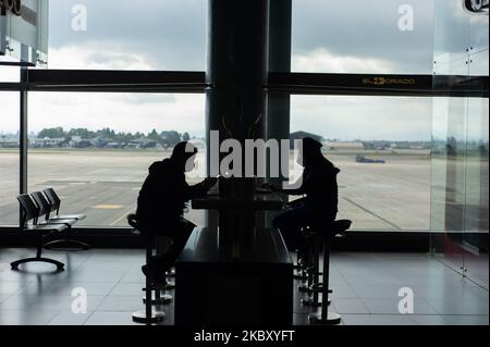 Due persone si siedono ad un tavolo separato presso l'aeroporto di El Dorado dopo cinque mesi di inattività l'aeroporto internazionale di El Dorado si prepara con misure di biosicurezza per prevenire la diffusione del nuovo Coronavirus per riprendere le attività il primo settembre con 14 diferent domesitc rotte a Bogotà, Colombia il 31 agosto 2020. (Foto di Sebastian Barros/NurPhoto) Foto Stock