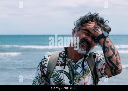 Un uomo moderno di mezza età in camicia informale sulla spiaggia Foto Stock