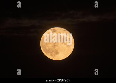 La Luna piena di mais, vista dietro la montagna Hortiatis sopra la città di Salonicco nel nord della Grecia, catturata dalla Laguna di Kalochori e dal Parco Nazionale. Il satellite naturale della terra come visto giallo e poi luminoso illuminando e creando riflessi sull'acqua di mare. La fase lunare, la Luna di mais avviene una volta ogni tre anni ed è anche conosciuta come Luna di frutta, Luna di Barley, Luna fantasma affamata, Binara pura Pasalosvaka Poya Day, Luna piena di Miele per i buddisti ecc. Thessaloniki, Grecia il 2 settembre 2020. (Foto di Nicolas Economou/NurPhoto) Foto Stock