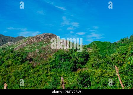 Paesaggio di montagne con foresta tropicale verde e strada al centro, alba nella giungla, con nuvole Foto Stock
