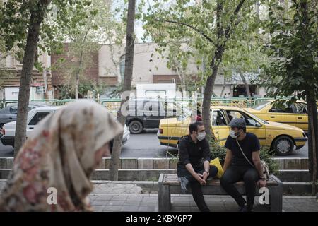 Due uomini iraniani che indossano maschere protettive siedono su una strada nel quartiere commerciale di Teheran in mezzo alla nuova epidemia di coronavirus (COVID-19) in Iran, il 5 luglio 2020. (Foto di Morteza Nikoubazl/NurPhoto) Foto Stock