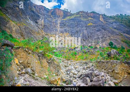 Paesaggio di montagne con foresta tropicale verde e strada al centro, alba nella giungla, con nuvole Foto Stock