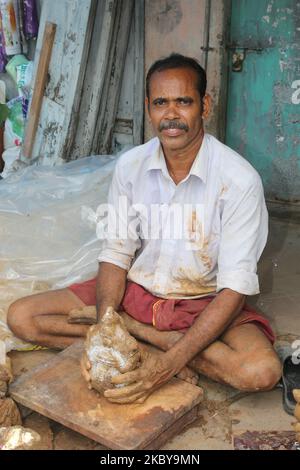 L'artigiano Tamil aggiunge una base di argilla mentre crea un piccolo idoli di argilla di Lord Ganesha (Lord Ganesh) in un laboratorio durante il festival di Ganesh Chaturthi a Pondicherry (Puducherry), Tamil Nadu, India il 26 agosto 2017. Ganesh Chaturthi (noto anche come Vinayaka Chaturthi) è un festival indù che celebra l'arrivo di Ganesh sulla terra da Kailash Parvat con sua madre Dea Parvati. Il festival è segnato con l'installazione di Ganesh idoli argilla privatamente in case e pubblicamente su elaborati pandali (templi temporanei lungo la strada). (Foto di Creative Touch Imaging Ltd./NurPhoto) Foto Stock