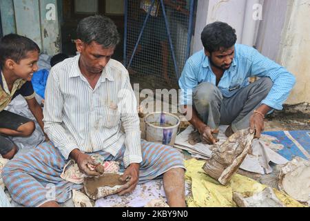 Gli artigiani Tamil tengono stampi riempiti di argilla mentre creano un piccolo idoli di argilla di Lord Ganesha (Lord Ganesh) in un laboratorio durante il festival di Ganesh Chaturthi a Pondicherry (Puducherry), Tamil Nadu, India il 26 agosto 2017. Ganesh Chaturthi (noto anche come Vinayaka Chaturthi) è un festival indù che celebra l'arrivo di Ganesh sulla terra da Kailash Parvat con sua madre Dea Parvati. Il festival è segnato con l'installazione di Ganesh idoli argilla privatamente in case e pubblicamente su elaborati pandali (templi temporanei lungo la strada). (Foto di Creative Touch Imaging Ltd./NurPho Foto Stock