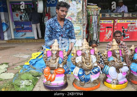 Tamil uomo che vende piccoli idoli di argilla di Lord Ganesha (Lord Ganesh) lungo la strada durante il festival di Ganesh Chaturthi a Pondicherry (Puducherry), Tamil Nadu, India il 26 agosto 2017. Ganesh Chaturthi (noto anche come Vinayaka Chaturthi) è un festival indù che celebra l'arrivo di Ganesh sulla terra da Kailash Parvat con sua madre Dea Parvati. Il festival è segnato con l'installazione di Ganesh idoli argilla privatamente in case e pubblicamente su elaborati pandali (templi temporanei lungo la strada). (Foto di Creative Touch Imaging Ltd./NurPhoto) Foto Stock