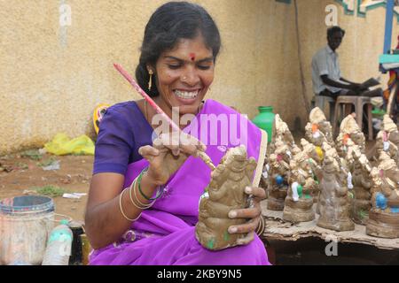 Tamil donna dipingere piccoli idoli di argilla di Lord Ganesha (Lord Ganesh) in un laboratorio di idolo lungo la strada durante il festival di Ganesh Chaturthi a Kaddalur, Tamil Nadu, India il 26 agosto 2017. Ganesh Chaturthi (noto anche come Vinayaka Chaturthi) è un festival indù che celebra l'arrivo di Ganesh sulla terra da Kailash Parvat con sua madre Dea Parvati. Il festival è segnato con l'installazione di Ganesh idoli argilla privatamente in case e pubblicamente su elaborati pandali (templi temporanei lungo la strada). (Foto di Creative Touch Imaging Ltd./NurPhoto) Foto Stock