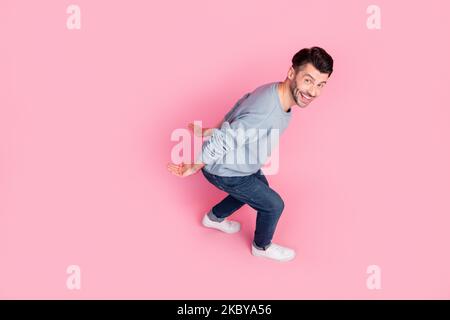 Foto a tutta lunghezza vista ad angolo alto di attraente giovane uomo piggyback tenere copyspace indossare elegante look blu isolato su sfondo di colore rosa Foto Stock