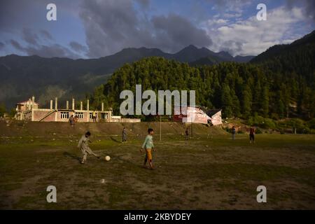 I bambini di Kashmiri giocano a calcio mentre piove nel distretto di Ganderbal, indiano amministrato Kashmir il 08 settembre 2020. (Foto di Muzamil Mattoo/NurPhoto) Foto Stock