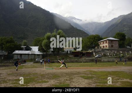 I bambini di Kashmiri giocano il cricket mentre piove nel distretto di Ganderbal, indiano amministrato il Kashmir il 08 settembre 2020. (Foto di Muzamil Mattoo/NurPhoto) Foto Stock