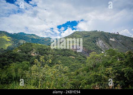 Paesaggio di montagne con foresta tropicale verde e strada al centro, alba nella giungla, con nuvole Foto Stock