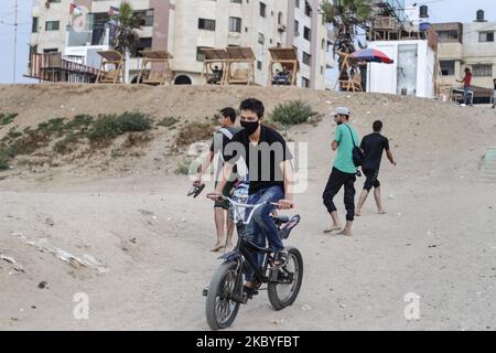 Un palestinese che indossa una maschera protettiva guida la sua bici vicino alla spiaggia di Gaza City, a seguito dello scoppio della malattia di coronavirus (COVID-19), a Gaza City, in Palestina, il 09 settembre 2020. (Foto di Sameh Rahmi/NurPhoto) Foto Stock