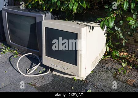 Vecchio televisore crt e monitor del computer lasciato sul marciapiede per la raccolta o lo smaltimento Foto Stock
