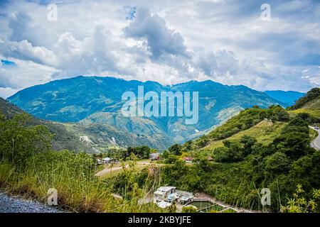 Paesaggio di montagne con foresta tropicale verde e strada nel mezzo, alba nella giungla, con nuvole Foto Stock