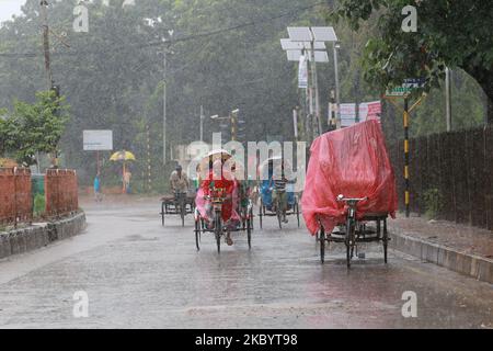 Gli uomini tirano i risciò durante la pioggia a Dhaka, Bangladesh, il 13 settembre 2020. (Foto di Rehman Asad/NurPhoto) Foto Stock