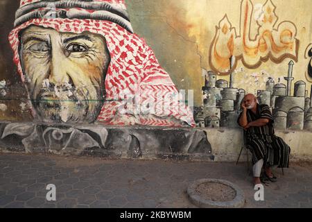 Un anziano palestinese siede di fronte a un murale fuori casa, nelle strade del campo profughi di Bureij, nella striscia centrale di Gaza, in mezzo alla pandemia COVID-19 del 14 settembre 2020. (Foto di Majdi Fathi/NurPhoto) Foto Stock