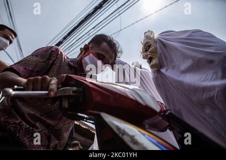 Tangerang District Health Administration eseguire la campagna 'Pocong' con le persone che utilizzano stoffa per le persone morte per educare le persone circa l'importante di utilizzare la maschera, mantenere la distanza, e lavare regolarmente. Il 16 settembre 2020 i 'Poig's' sono stati visitati dal mercato di Cipadu, a Tangerang, Banten, Indonesia. (Foto di Donal Husni/NurPhoto) Foto Stock