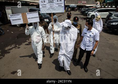 Tangerang District Health Administration eseguire la campagna 'Pocong' con le persone che utilizzano stoffa per le persone morte per educare le persone circa l'importante di utilizzare la maschera, mantenere la distanza, e lavare regolarmente. Il 16 settembre 2020 i 'Poig's' sono stati visitati dal mercato di Cipadu, a Tangerang, Banten, Indonesia. (Foto di Donal Husni/NurPhoto) Foto Stock