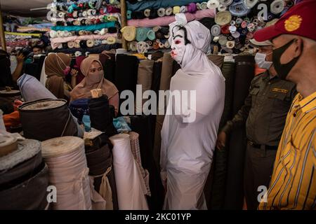 Tangerang District Health Administration eseguire la campagna 'Pocong' con le persone che utilizzano stoffa per le persone morte per educare le persone circa l'importante di utilizzare la maschera, mantenere la distanza, e lavare regolarmente. Il 16 settembre 2020 i 'Poig's' sono stati visitati dal mercato di Cipadu, a Tangerang, Banten, Indonesia. (Foto di Donal Husni/NurPhoto) Foto Stock