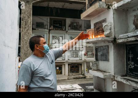 Un residente offre preghiere e candele sulle tombe dei loro cari al Manila North Cemetery a Metro Manila, a Manila, Filippine, il 16 settembre 2020. (Foto di Mohd Sarajan/NurPhoto) Foto Stock