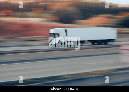 Il camion di carico bianco che attraversa la strada, esposizione lunga Foto Stock