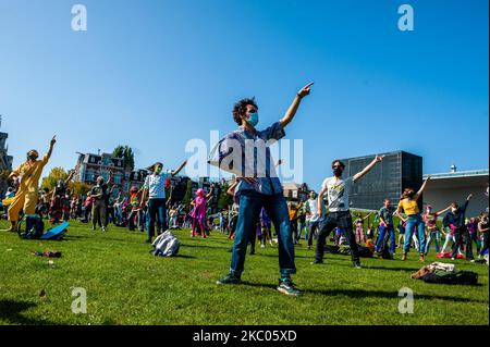 Manifestanti il 19th settembre 2020 ad Amsterdam, Paesi Bassi. Durante tutto il mese, il gruppo di attivisti climatici Extinction Rebellion nei Paesi Bassi ha pianificato una nuova campagna, con il nome di 'rivolta di settembre' per attirare l'attenzione sulla crisi climatica ed ecologica. Al Museumplein, ad Amsterdam, centinaia di attivisti della XR hanno ballato per chiedere azioni contro il cambiamento climatico in ciò che i manifestanti hanno definito ''disco-pubblico civile''. Gli attivisti sventolarono le bandiere e ballarono in canzoni tra cui l'hit del 1977 di Bee Gees, Stayin' Alive. Dopo la Museumplein gli attivisti si sono bloccati per alcuni minuti uno dei più Foto Stock