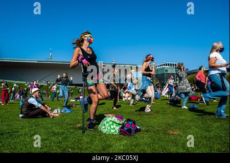 Manifestanti il 19th settembre 2020 ad Amsterdam, Paesi Bassi. Durante tutto il mese, il gruppo di attivisti climatici Extinction Rebellion nei Paesi Bassi ha pianificato una nuova campagna, con il nome di 'rivolta di settembre' per attirare l'attenzione sulla crisi climatica ed ecologica. Al Museumplein, ad Amsterdam, centinaia di attivisti della XR hanno ballato per chiedere azioni contro il cambiamento climatico in ciò che i manifestanti hanno definito ''disco-pubblico civile''. Gli attivisti sventolarono le bandiere e ballarono in canzoni tra cui l'hit del 1977 di Bee Gees, Stayin' Alive. Dopo la Museumplein gli attivisti si sono bloccati per alcuni minuti uno dei più Foto Stock