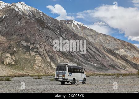 Veicolo sotto magnifiche montagne innevate in una remota valle dell'Himalayan a Zanskar, distretto di Kargil, Ladakh, Jammu e Kashmir, India. (Foto di Creative Touch Imaging Ltd./NurPhoto) Foto Stock