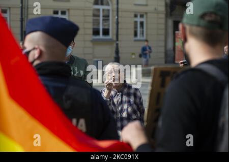 Una donna anziana mostra il dito medio a un uomo che tiene un segno e una bandiera LGBT durante una manifestazione pro-vita il 20 settembre 2020 a Varsavia, Polonia. Diverse migliaia di persone hanno partecipato a una marcia pro life sotto lo slogan ''insieme difendiamo la famiglia'', per dimostrare contro l'aborto e per difendere i valori familiari e cattolici in risposta alle ultime azioni di disobbedienza civile da parte degli attivisti LGBT e di sinistra. La manifestazione ha anche visto la partecipazione del presidente polacco Andrzej Duda. (Foto di Aleksander Kalka/NurPhoto) Foto Stock