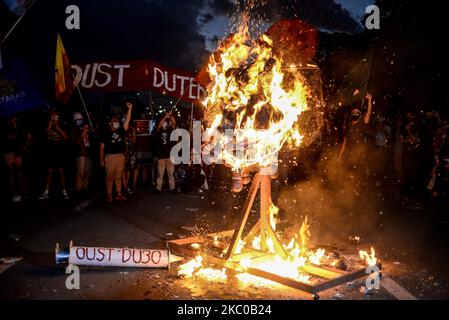 Gli attivisti sollevano i loro pugni chiusi come un effigero ritratto del presidente filippino Rodrigo Duterte come un virus è bruciato durante una protesta il 48th ° anniversario della dichiarazione di legge marziale nelle Filippine, a Quezon City, Filippine il 21 settembre 2020.(Foto di Lisa Marie David/NurPhoto) Foto Stock