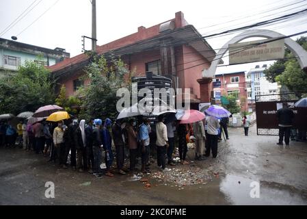 I nepalesi e i lavoratori migranti indiani insieme ad un rivestimento ombrello per il test PCR all'esterno al Sukraraj Tropical & Infectious Disease Hospital, Teku, Kathmandu, Nepal il 24 settembre 2020. (Foto di Narayan Maharjan/NurPhoto) Foto Stock