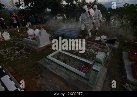 Gli ufficiali spruzzano liquido disinfettante per prevenire la diffusione di COVID-19 in una zona di sepoltura affollata di pellegrini, a Palu, nella provincia di Sulawesi centrale, Indonesia, il 28 settembre, 2020. Sulla base dei dati forniti dal governo indonesiano fino al 28 settembre 2020, il numero di persone che sono state confermate positive per COVID-19 in Indonesia ha raggiunto 278.722 persone e 206.870 persone sono state dichiarate curate e 10.473 sono morte. (Foto di Mohamad Hamzah/NurPhoto) Foto Stock