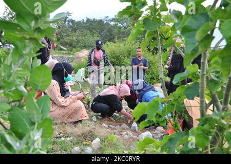 Un certo numero di residenti stanno pulendo le tombe della loro famiglia al cimitero di massa per le vittime del terremoto, dello tsunami e del disastro di liquefazione, nel villaggio di Poboya, nella città di Palu, nella provincia centrale di Sulawesi, lunedì, Settembre 28, 2020. Questo è stato fatto per commemorare e pregare per le vittime del terremoto, dello tsunami e del disastro della liquefazione. Colpì le città di Palu, Sigi e Dongala il 28 settembre 2018, causando la morte di migliaia di residenti. (Foto di Faldi Muhammad/NurPhoto) Foto Stock