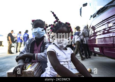 I bambini si pongono per una foto mentre i rifugiati provenienti dalle isole di Lesbos, Chios, Samos, Kos e Leros aspettano di salire a bordo degli autobus dopo essere sbarcati al porto di Lavrio, a circa 70 km a sud-est di Atene, prima di essere trasferiti nei campi della Grecia continentale, il 29 settembre 2020. I primi gruppi di 724 rifugiati dal campo di Moria eviscerato e altri 210 dai campi di altre isole dell'Egeo sono stati trasferiti il 29 settembre 2020, nel tentativo di decongestionare i campi di isole sovraffollate. (Foto di Dimitris Lampropoulos/NurPhoto) Foto Stock