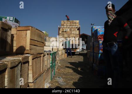 I lavoratori di Kashmiri trasportano scatole di prodotti da caricare su camion in un mercato all'ingrosso della frutta a Sopore, distretto di baramulla, Jammu e Kashmir, India, circa 54kms km a nord di Srinagar, il 02 ottobre 2020. Recentemente, i coltivatori e gli acquirenti di mele presso Fruit Mandi nella zona di Sopore, nel distretto nord del Kashmir Baramulla, hanno organizzato una protesta contro il governo per â€œfailingâ€ per rimediare alle loro questioni. (Foto di Nasir Kachroo/NurPhoto) Foto Stock