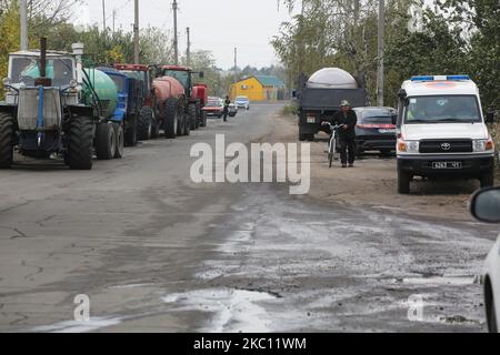 I carri armati forniti dagli agricoltori locali portano un'acqua per soddisfare i veicoli dei vigili del fuoco per spegnere l'incendio nella regione di Luhansk, Ucraina, 2 ottobre 2020. Centinaia di persone sono state evacuate, otto sono morte, alcuni villaggi sono bruciati, più di 30 potrebbero essere colpiti dalle fiamme, poiché nella regione orientale dell'Ucraina di Luhansk si scatenano incendi boschivi su larga scala. (Foto di Sergii Kharchenko/NurPhoto) Foto Stock