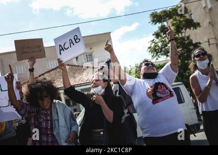 I giovani manifestanti tunisini che mettono le dita del mezzo, urlano slogan mentre sollevano un cartello con la scritta “ACAB”, nel corso di una manifestazione svoltasi al di fuori dell’edificio del Parlamento tunisino a Bardo, Tunisi, per protestare contro il nuovo progetto di legge di protezione delle forze di sicurezza. Tunisia il 8 ottobre 2020. (Foto di Chardy ben Ibrahim/NurPhoto) Foto Stock