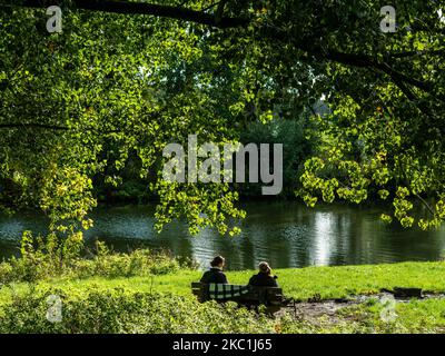 Un paio di donne si godono il sole, seduti su una panchina vicino ad un fiume, nei Paesi Bassi, il 10th ottobre 2020. (Foto di Romy Arroyo Fernandez/NurPhoto) Foto Stock