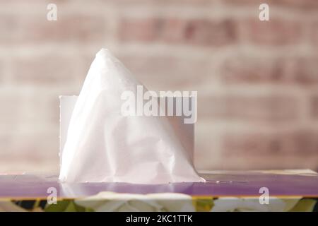 estrarre manualmente un pezzo di tessuto dalla scatola di carta per tessuti Foto Stock